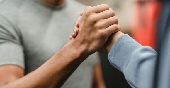 Man Wellness - Crop sportive couple clasping hands in gym